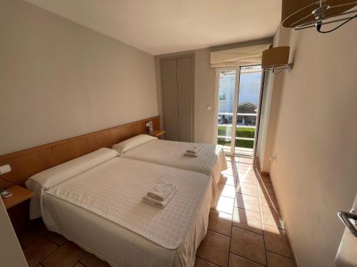 a small bedroom with a bed and a balcony at Villas El Pinaret - Serviden in Pedreguer