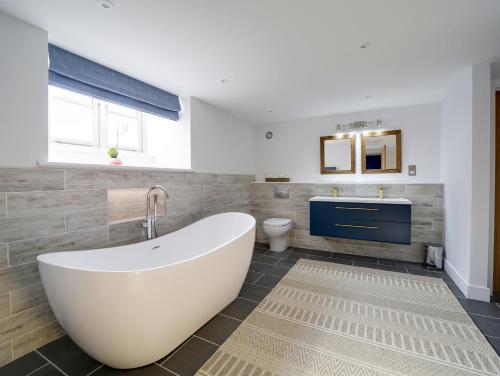 La salle de bains est pourvue d'une baignoire, de toilettes et d'un lavabo. dans l'établissement Joinery Cottage, à Porthleven