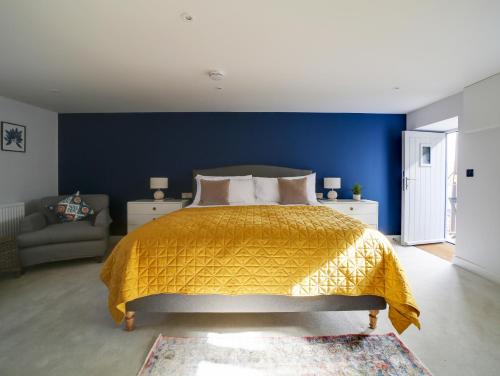 - une chambre avec un lit et un mur bleu dans l'établissement Joinery Cottage, à Porthleven