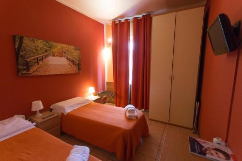 MeroneにあるHotel Pontenuovoのベッド2台とテレビが備わるホテルルームです。