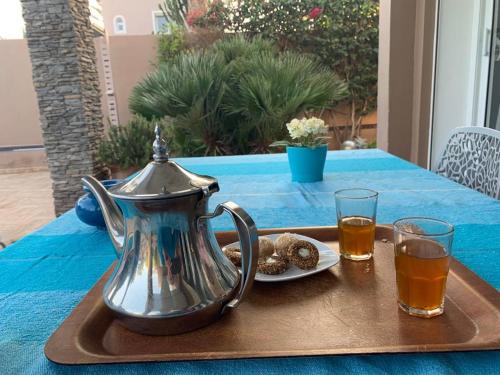 taca z czajnikiem do herbaty i ciasteczkami na stole w obiekcie Chalet Mirleft w mieście Mirleft