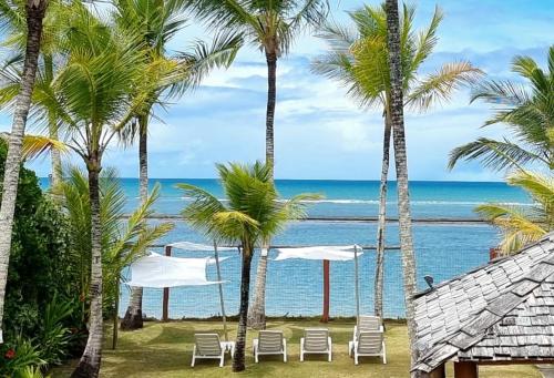 Blick auf den Strand von einem Resort mit Palmen in der Unterkunft Vista para o mar Arraial d'Ajuda in Arraial d'Ajuda