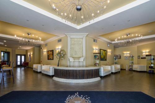 a large lobby with white chairs and a chandelier at Hotel Terme Capasso in Contursi