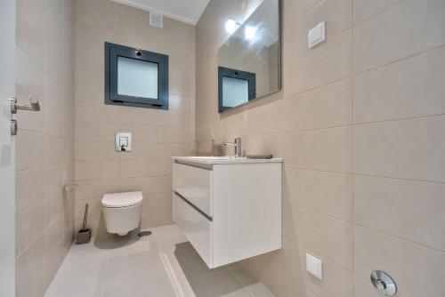 un bagno con un water, un lavandino e uno specchio di Villa Foz - By SCH a Foz do Arelho