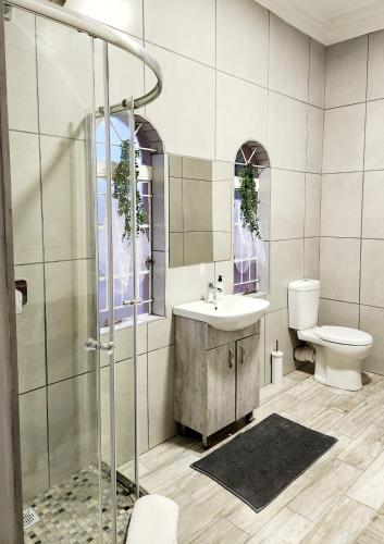a bathroom with a shower and a sink and a toilet at Be My Guest Too in Upington