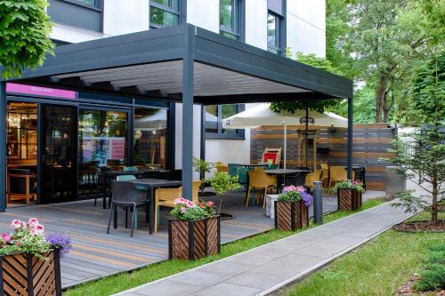 a restaurant with a black roof and tables and chairs at ibis Styles Warszawa Centrum in Warsaw