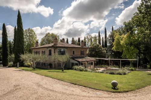 een oud huis op een grasveld met bomen bij Il Casale - Umbria Top Rent in Massa Martana