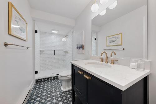 a white bathroom with a sink and a toilet at Beautiful Condo Steps from Shoreline Park - A in Sandusky