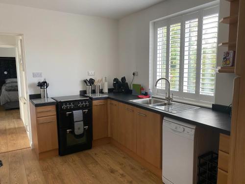 a kitchen with a stove top oven next to a sink at Corner Retreat Holiday Let Seahouses in Seahouses