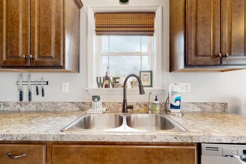 eine Küchentheke mit einem Waschbecken und einem Fenster in der Unterkunft Ruftop Ridge in Hammondsport