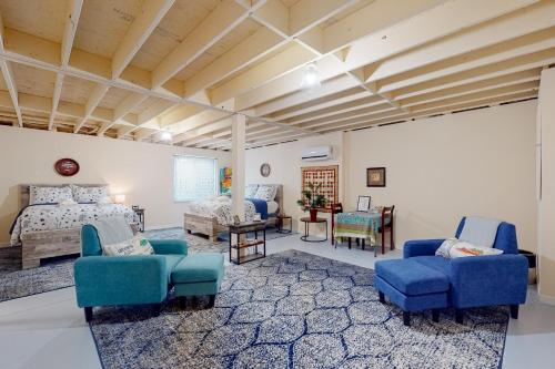 a bedroom with a bed and two blue chairs at Ruftop Ridge in Hammondsport