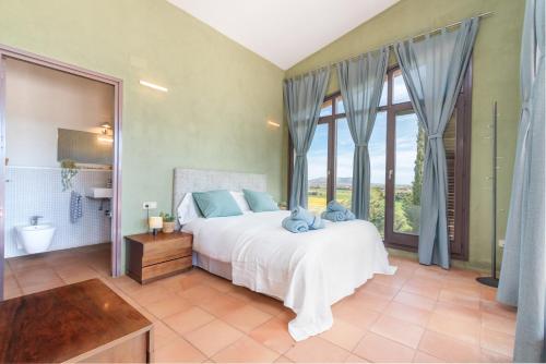 een slaapkamer met een bed en een groot raam bij Mas Darovie in Foixá