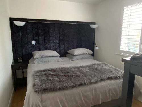 ein Schlafzimmer mit einem großen Bett mit großem Kopfteil in der Unterkunft Corner Retreat Holiday Let Seahouses in Seahouses