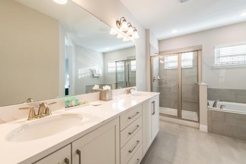 ein Badezimmer mit zwei Waschbecken und einem großen Spiegel in der Unterkunft Ultra Upgraded Home by Rentyl with Pool Slide and Game Room near Disney - 384S in Orlando