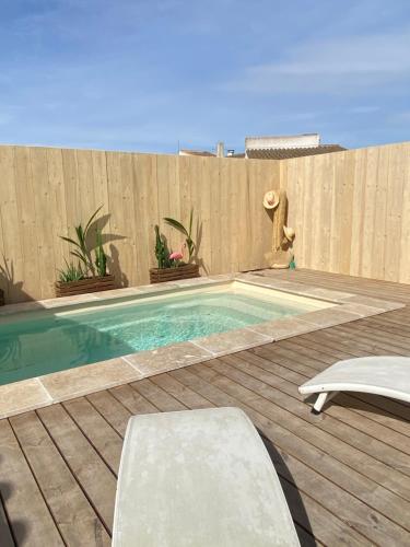 - une piscine dans un jardin avec une clôture en bois dans l'établissement Mas des Oliviers, maison avec piscine privative et chauffée LOCAMARGUE, à Maguelonne-la-Sauvage