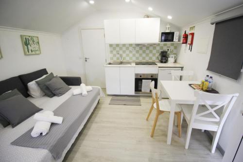 a living room with a couch and a table and a kitchen at Oriente DNA Studios in Lisbon