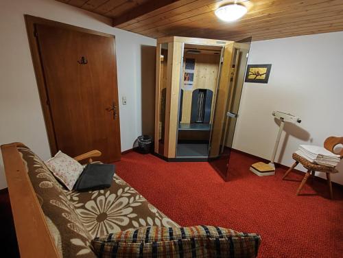 a living room with a couch and a open door at Hotel Gut Kramerhof in Kirchdorf in Tirol