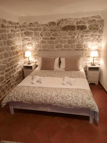 a bedroom with a bed with two lamps on two tables at Room Ivana in Rab