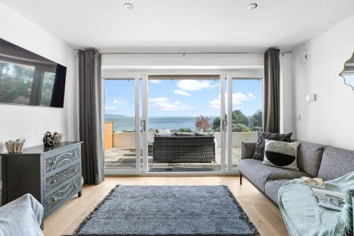a living room with a couch and a view of the ocean at Osprey 3, The Cove - Sea view - On site pool in Brixham