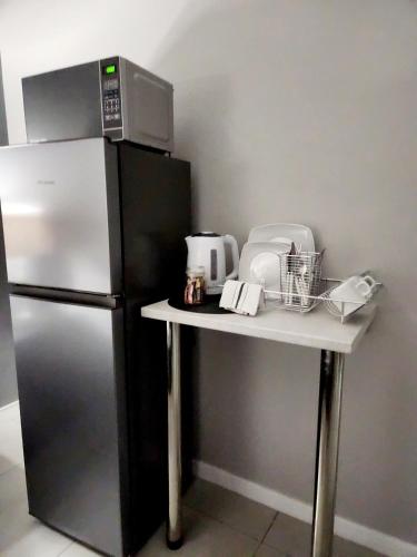 a kitchen with a refrigerator and a table with a microwave at Be My Guest Too in Upington