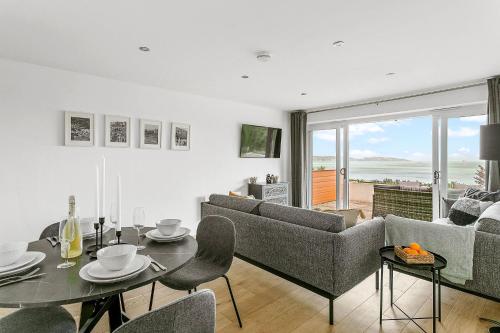 a living room with a couch and a table and chairs at Osprey 3, The Cove - Sea view - On site pool in Brixham