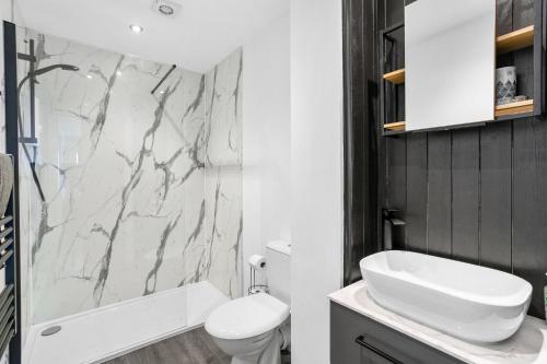 La salle de bains est pourvue de toilettes blanches et d'un lavabo. dans l'établissement Osprey 3, The Cove, Brixham, à Brixham