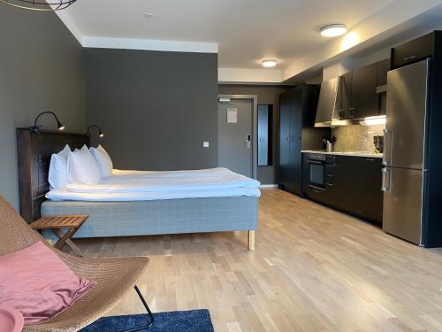 a small room with a bed and a kitchen at Magnolia House Norrviken in Sollentuna