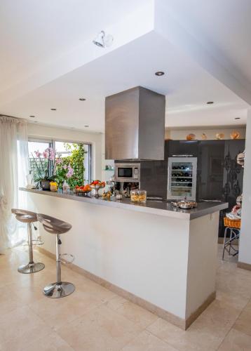une cuisine avec un comptoir et des tabourets dans l'établissement EXCEPTIONAL! PENTHOUSE in front of Monte Carlo Beach and Tennis Club, à Roquebrune-Cap-Martin
