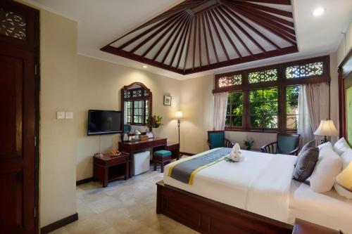 sypialnia z dużym łóżkiem i telewizorem w obiekcie Royal Tunjung Hotel & Villa Legian - CHSE Certified w mieście Legian