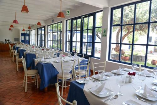 a row of tables in a room with windows at La Casa de Fray Bartolome in Cusco