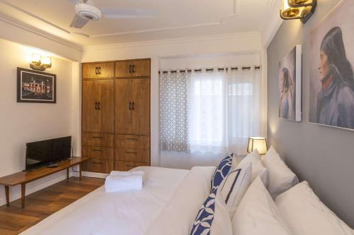 a living room with a white couch and a television at Zostel Homes Shimla in Shimla