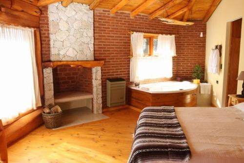 a large room with a bed and a bath tub at Posada Piñen in Mar de las Pampas