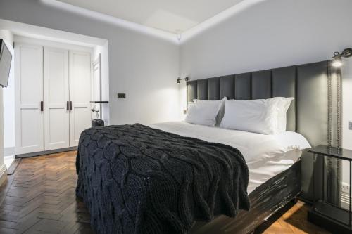 a bedroom with a large bed with a black blanket at The Marlborough Suite in London