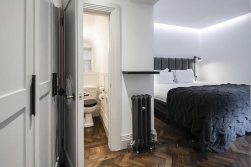 a bedroom with a bed and a bathroom at The Marlborough Suite in London