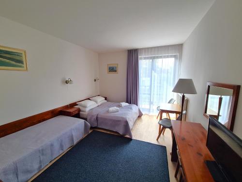Pokoje Gościnne Albatros في فواديسوافوفو: غرفة فندقية بسريرين وتلفزيون بشاشة مسطحة
