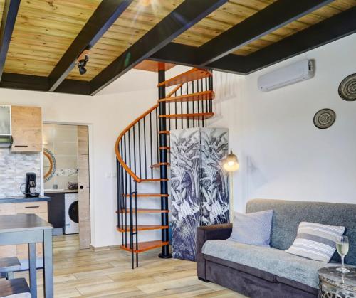 a living room with a spiral staircase in a house at L'INSTANT D'ÉVASION 1 Plaine des cafres in La Plaine des Cafres