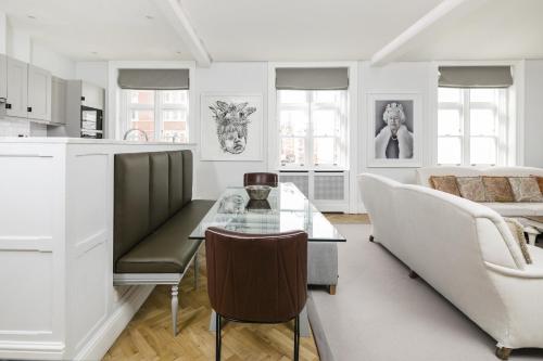 a kitchen and living room with a table and a couch at The Connaught Suite in London