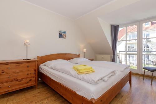 um quarto com uma cama com toalhas amarelas em Strandjuwel 251 em Kühlungsborn