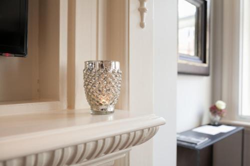 a glass vase sitting on a shelf in a room at The Grosvenor Square Penthouse in London