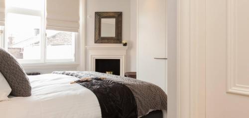 a bedroom with a bed with a mirror and a window at The Grosvenor Square Penthouse in London