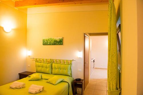 a bedroom with a green bed with two towels on it at Le Murette appartamenti in Affi