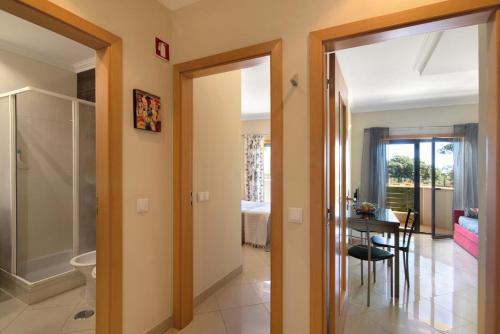 um corredor com uma porta aberta para um quarto com uma mesa em Apartamento T1 - Em zona tranquila nos Olhos de Água