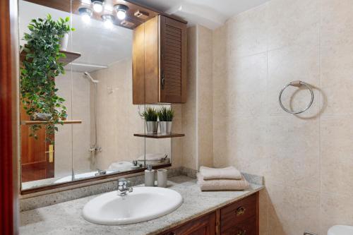 a bathroom with a sink and a mirror at Casa Playa Palmeras in Puerto del Carmen