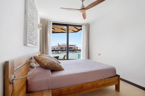a bedroom with a bed and a large window at Apartamento Nautilus sea view in El Cotillo