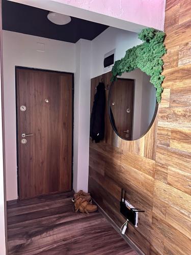 a bathroom with a mirror and a wooden wall at Apartamente A&A in Târgu Ocna