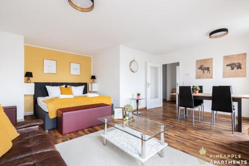 uma sala de estar com uma cama e uma mesa em Pineapple Apartments Dresden Mitte III - free parking em Dresden