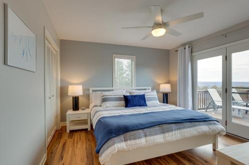 Schlafzimmer mit einem Bett mit blauer Bettwäsche und einem Fenster in der Unterkunft Spacious Hammondsport Home on 6 Acres with Lake View in Hammondsport