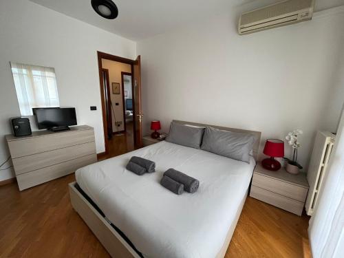 um quarto com uma cama branca com duas almofadas em BedandBreakfast Eni Torri Lombarde San Donato BBqueen em San Donato Milanese