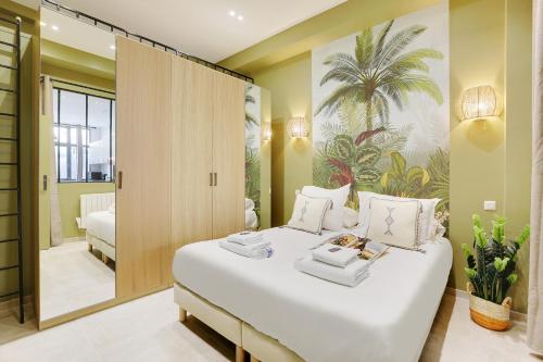 una camera da letto con un grande letto bianco e uno specchio di CMG Ramey / Sacré-Coeur III a Parigi