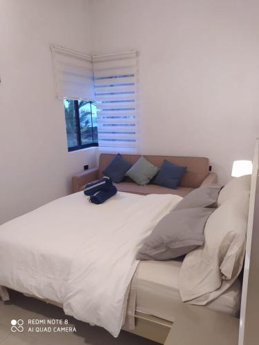 a bedroom with a large white bed and a window at Casa Suite Palmar del viento FRENTE, FRENTE AL MAR by Amauna in Moñitos